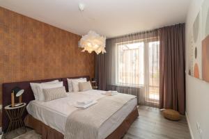Un dormitorio con una cama grande y una lámpara de araña. en Contemporary Charm in Old Sofia, en Sofía