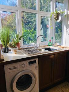 a kitchen with a washing machine and a sink at Large Home with 5 car Parking next to Train station, Airport, NEC in Marston Green