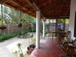 un porche avec des chaises et une table et une clôture dans l'établissement Leena marari beach house, à Alappuzha