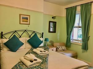 a bedroom with two beds with towels on them at Pickwicks Guest House in Oxford