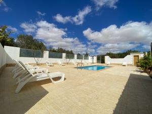 a patio with two lounge chairs and a pool at El Olivar Experiences - Adults Recommended in Puerto del Rosario