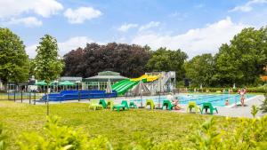una piscina con sillas verdes y amarillas en un parque en Molecaten Park Landgoed Ginkelduin, en Leersum