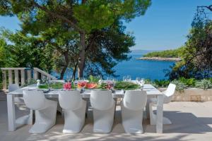 a white table and chairs with a view of the ocean at Villa Acona Selca - film star looks in a glamorous setting with amazing facilities in Selca