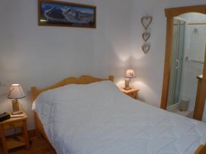 um quarto com uma cama branca e 2 candeeiros em Appartement Samoëns, 3 pièces, 6 personnes - FR-1-629-89 em Samoëns