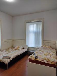 two beds sitting in a room with a window at City Home Zurich in Zurich
