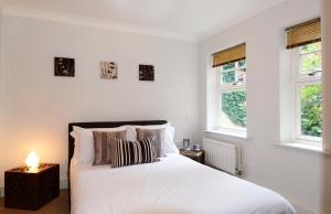 a bedroom with a white bed with two windows at Elizabeth Jennings Way in Oxford