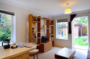 a living room with a desk and a tv and two windows at Elizabeth Jennings Way in Oxford