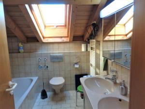 a bathroom with a sink and a tub and a toilet at Haus Fellner**** in Brannenburg +21 photos