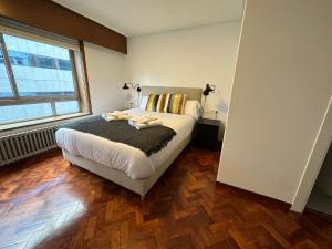 a bedroom with a bed and a large window at Oktheway Big Coruña in A Coruña