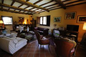 Una sala de estar con sofás y sillas y un televisor. en Agriturismo val di Coreto, en Bagnoregio