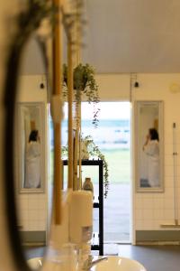 a woman taking a picture in a bathroom mirror at Laguna Beach Family Camps Öland in Mörbylånga