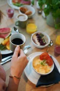 a person holding a cup of coffee and a plate of food at Comfort Hotel City in Gothenburg