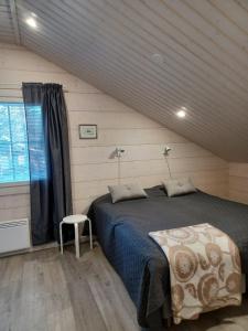 a bedroom with a large bed and a window at Levi President Suksitie Chalet in Levi