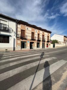 a shadow of a person crossing a street at Hostal Corper Navalcarnero in Navalcarnero