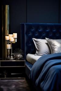a blue bedroom with a bed with a blue headboard at Die Heerenhuys Guest Suites in Stellenbosch