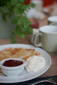 a plate of pancakes with jam and a bowl of butter at Comfort Hotel City in Gothenburg