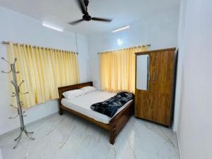 - une petite chambre avec un lit et un miroir dans l'établissement Furnished 2 BHK Family Apartments near Triprayar Shree Rama Temple - Beevees Homes Thriprayar, à Thanniyam
