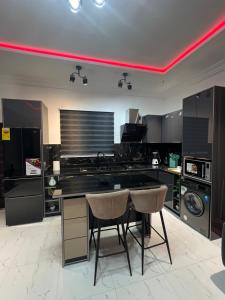 a kitchen with a black counter and two chairs at Akua’s Cottage in Accra