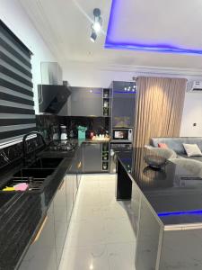 a kitchen with a black counter top and a living room at Akua’s Cottage in Accra