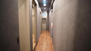 a hallway with a long wooden floor in a building at HOSTEL OE in Yoshinogawa