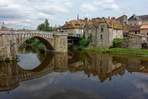 eine Brücke über einen Fluss in einer Stadt mit Häusern in der Unterkunft A l'école... buissonnière in Montmorillon