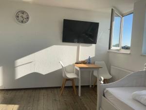 a room with a desk and a tv on a wall at Über den Dächern von Essen in Essen