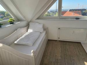 - un lit dans une chambre avec 2 fenêtres dans l'établissement Über den Dächern von Essen, à Essen