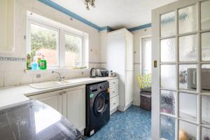 a kitchen with a sink and a washing machine at Haven Home in Bristol