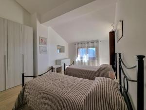1 dormitorio con 2 camas y ventana en Villa Rosa, en Latronico