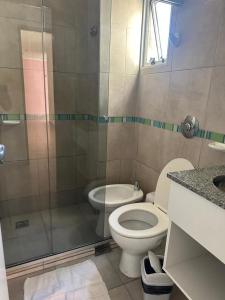 a bathroom with a toilet and a glass shower at HOTEL DIAMANTE in Resistencia