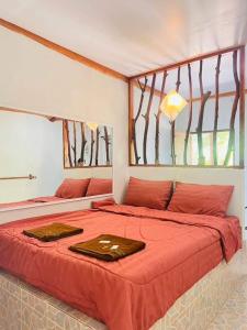 สบายคันทรีรีสอร์ท ปากเมงSa-buy country resort Pak Meng tesisinde bir odada yatak veya yataklar