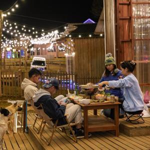 un grupo de personas sentadas alrededor de una mesa comiendo comida en Rumhaoy Maison, en Phumĭ Pu Pal