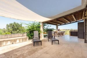 eine Außenterrasse mit Stühlen und einem Tisch mit Aussicht in der Unterkunft Casa Degli Aromi in Noto