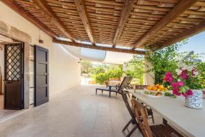 eine Außenterrasse mit einem Tisch und Stühlen in der Unterkunft Casa Degli Aromi in Noto