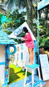 kobieta stojąca na krześle w domu zabaw w obiekcie Omkar wellness inn w mieście Arambol