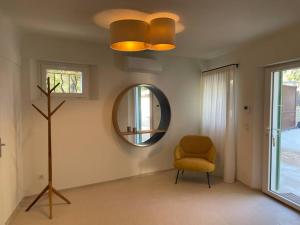 sala de estar con silla y espejo en Bastide De Charme Sud Luberon, en Saint-Martin-de-la-Brasque