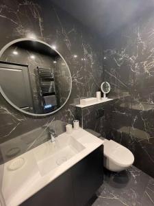y baño con lavabo, espejo y aseo. en Bastide De Charme Sud Luberon, en Saint-Martin-de-la-Brasque
