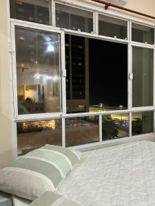 a bedroom with a large window with a view of a city at COPACABANA RIO PRAIA 15 in Rio de Janeiro