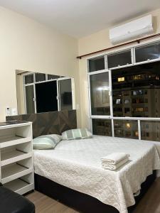 a bedroom with a bed and a large window at COPACABANA RIO PRAIA 15 in Rio de Janeiro