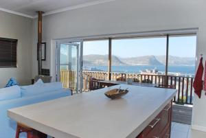 Sala de estar con mesa y vistas al océano en The Grosvenor Guest House & Self Catering, en Simonʼs Town