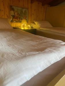 duże białe łóżko w sypialni z lampką w obiekcie Casa Emy w mieście Adrara San Rocco