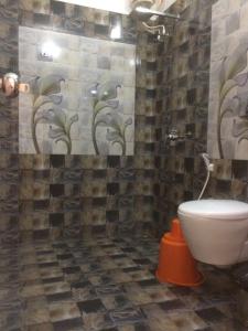 une salle de bain avec toilettes et un mur carrelé dans l'établissement Leena marari beach house, à Alappuzha 22 autres photos