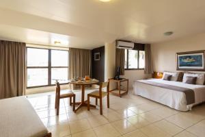 a hotel room with a bed and a table at Uberaba Hotel Suítes in Uberaba +24 photos
