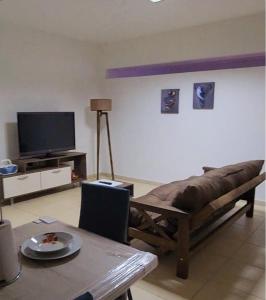 sala de estar con sofá y TV en Complejo Andes en Godoy Cruz