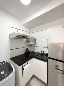 a small kitchen with a sink and a refrigerator at Hermoso Loft Zona Shopping Sol 02 in Asuncion