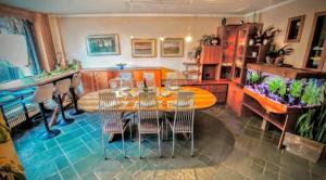 - une salle à manger avec une table, des chaises et un coffre à poisson dans l'établissement Villa Panoramica - 200Mq - SPA - Giardino Privato - 0039-34893-66818, à Aoste