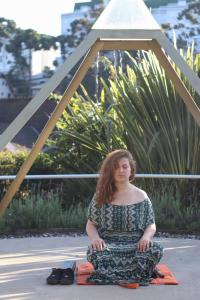 una mujer sentada en el suelo en una pose de yoga en Pousada Recanto Feliz, en Campos do Jordão