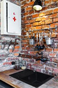 a brick wall in a kitchen with a sink at HOUSEHOST ApartmenI: Podbrzezie 2/20 in Krakow