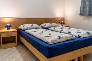 a bedroom with two beds with blue and white sheets at Chalet Al Lago in Alleghe