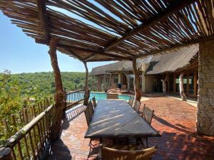 een patio met een tafel en een zwembad bij Reedbuck Lodge @Cyferfontein in Mabalingwe Reserve in Bela-Bela